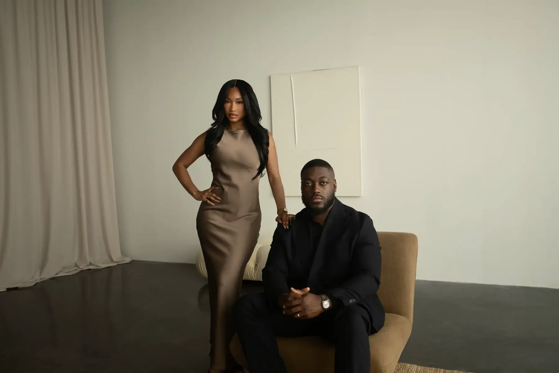 Aïcha standing and Idriss seated together in the studio, facing the camera